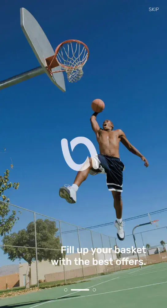 An athletic man jumping with a basketball for a dunk on an outdoor court, with The Voucher App Logo and the phrase 'Fill up your basket with the best offers' displayed on the image.